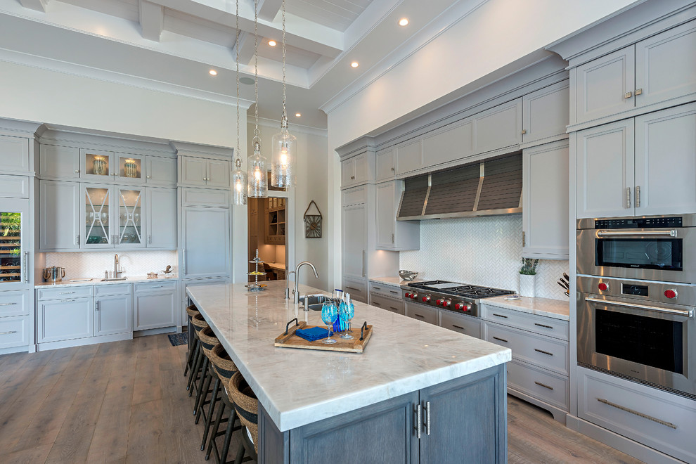 Example of a medium tone wood floor open concept kitchen design with stainless steel appliances and an island