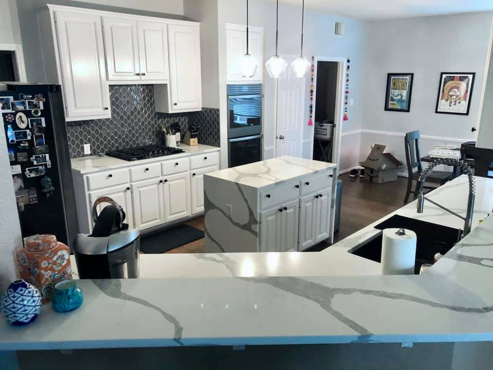 Photo of a small transitional u-shaped eat-in kitchen in Austin with an undermount sink, recessed-panel cabinets, white cabinets, quartz benchtops, blue splashback, ceramic splashback, black appliances, plywood floors, with island, brown floor and multi-coloured benchtop.