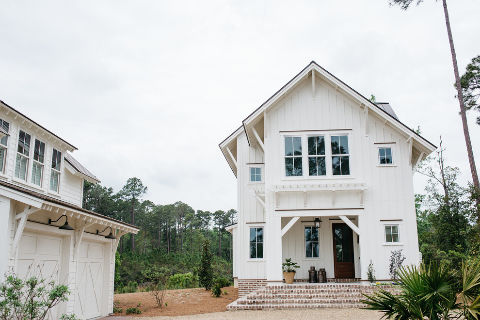 Diseño de fachada de casa blanca campestre de tamaño medio de dos plantas con revestimiento de aglomerado de cemento, tejado a dos aguas y tejado de metal