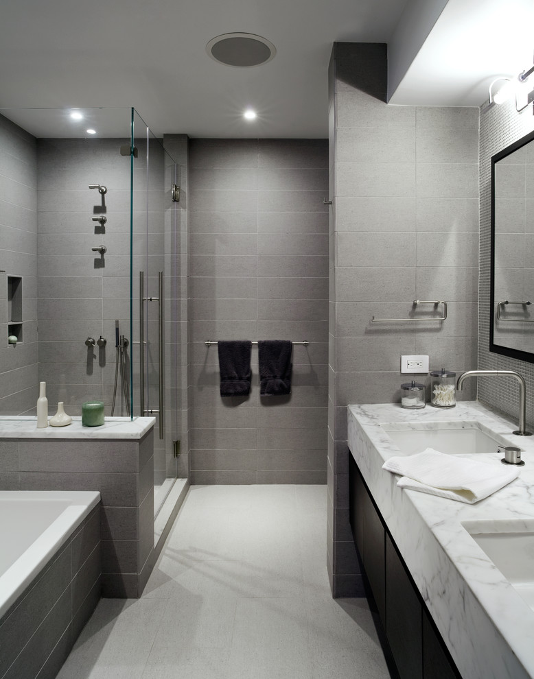 Example of a trendy gray tile bathroom design in New York with marble countertops, an undermount sink, flat-panel cabinets and dark wood cabinets