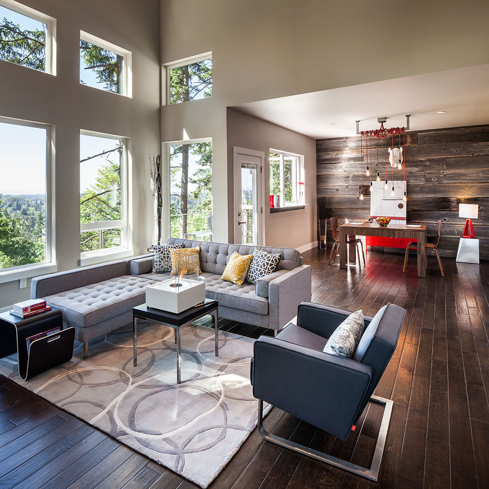 This is an example of a large contemporary open concept living room in Portland with grey walls and dark hardwood floors.