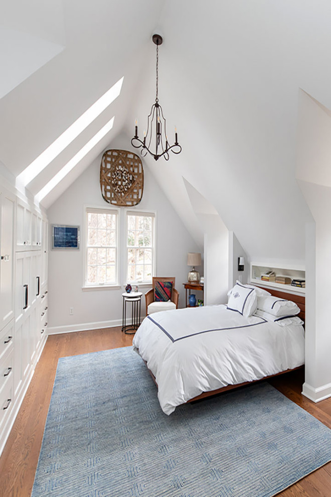 Imagen de dormitorio principal y abovedado tradicional renovado grande con paredes blancas, suelo de madera en tonos medios y suelo marrón