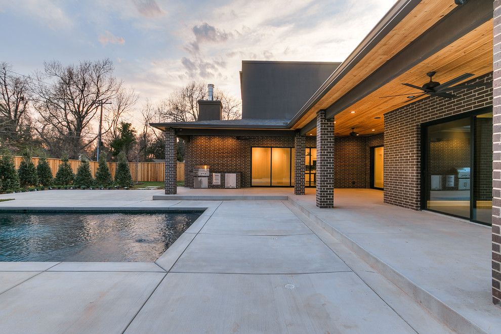 Design ideas for an expansive modern two-storey brick brown house exterior in Oklahoma City with a flat roof.