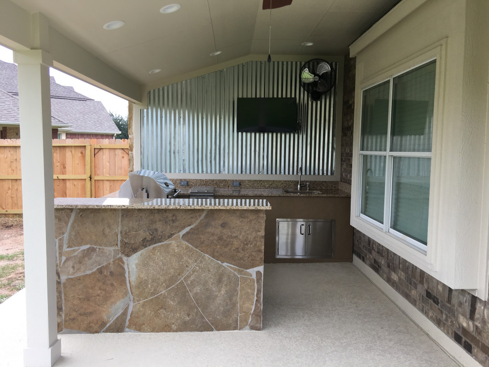Inspiration for a mid-sized backyard patio in Houston with an outdoor kitchen, stamped concrete and a roof extension.