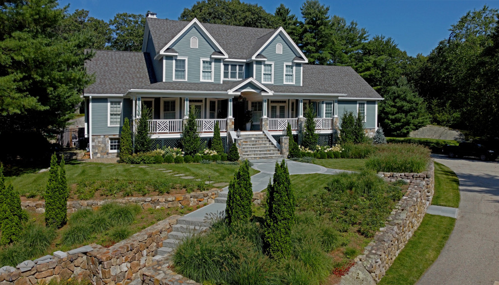 Immagine della villa grande blu country a due piani con rivestimenti misti, tetto a capanna, copertura a scandole, tetto grigio e pannelli sovrapposti