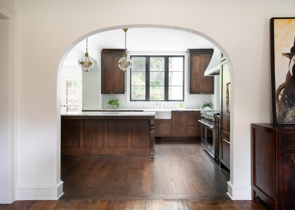 Exempel på ett stort klassiskt vit vitt kök och matrum, med en rustik diskho, luckor med infälld panel, skåp i mörkt trä, marmorbänkskiva, vitt stänkskydd, stänkskydd i keramik, integrerade vitvaror, mörkt trägolv, en köksö och brunt golv