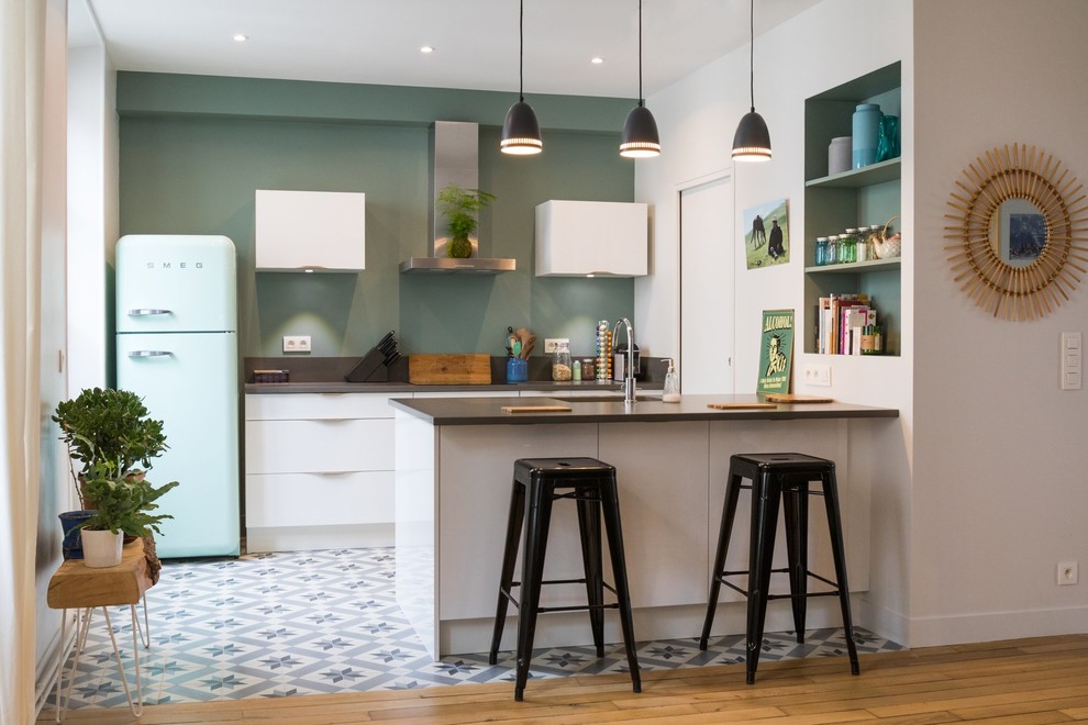 Mid-sized contemporary galley eat-in kitchen in Paris with an undermount sink, beaded inset cabinets, white cabinets, wood benchtops, brown splashback, timber splashback, stainless steel appliances, with island, blue floor and brown benchtop.