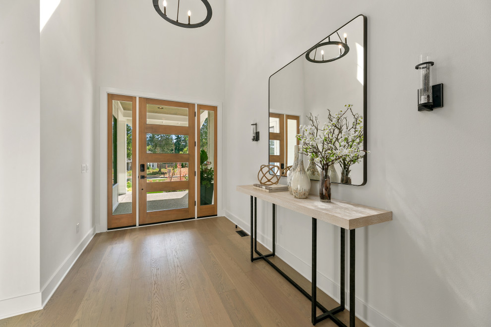 Photo of a large country front door in Seattle with white walls, light hardwood floors, a single front door, a medium wood front door, brown floor and recessed.