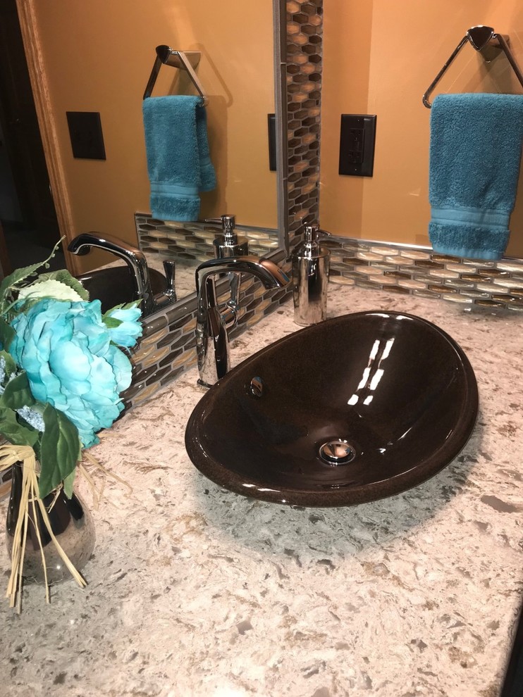 Mid-sized transitional multicolored tile and glass tile porcelain tile and beige floor bathroom photo with brown cabinets, orange walls, a vessel sink, quartz countertops and beige countertops