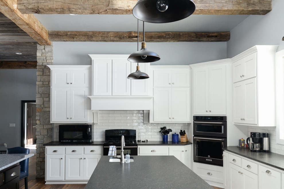 Example of a vinyl floor and brown floor kitchen design with recessed-panel cabinets, white cabinets, white backsplash and ceramic backsplash