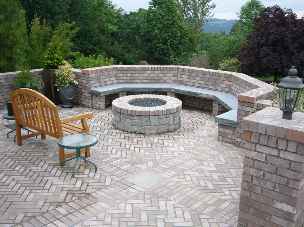 Design ideas for a traditional backyard patio in Portland with brick pavers.