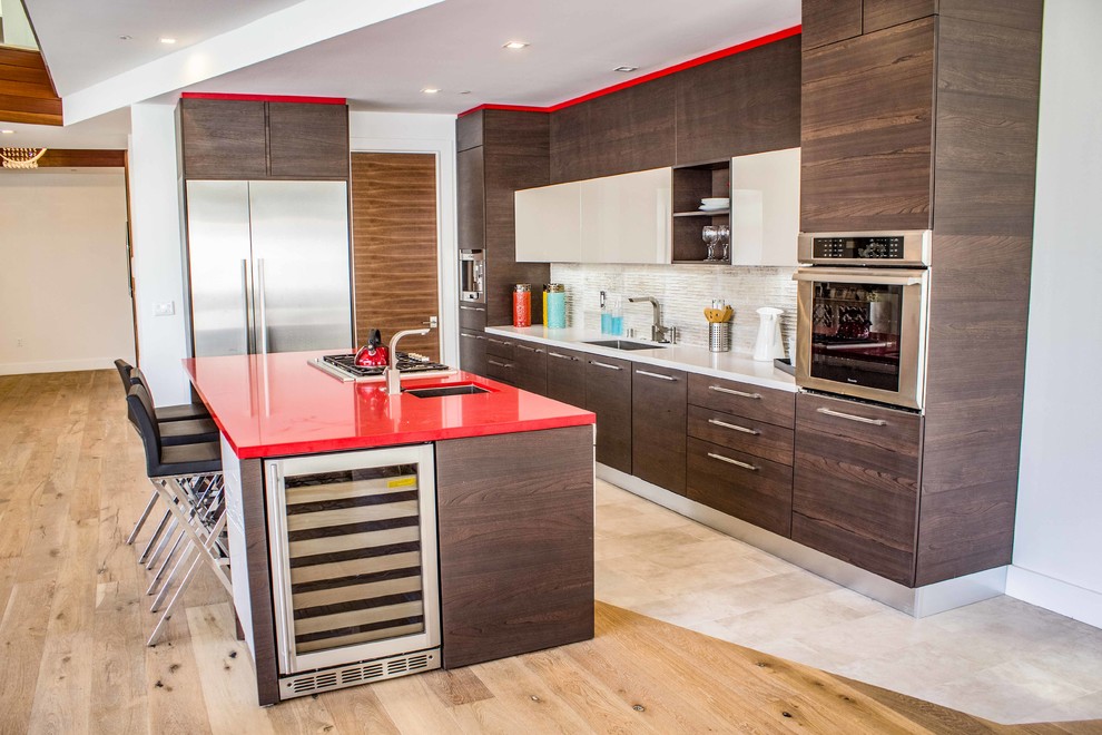 Mid-sized contemporary single-wall eat-in kitchen in Los Angeles with an undermount sink, flat-panel cabinets, dark wood cabinets, solid surface benchtops, white splashback, stainless steel appliances, light hardwood floors, with island, brown floor, red benchtop and ceramic splashback.