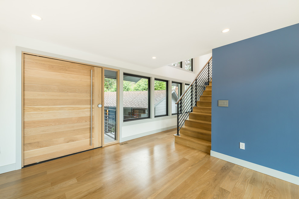 Inspiration for a mid-sized transitional light wood floor and beige floor front door remodel in Seattle with white walls and a light wood front door