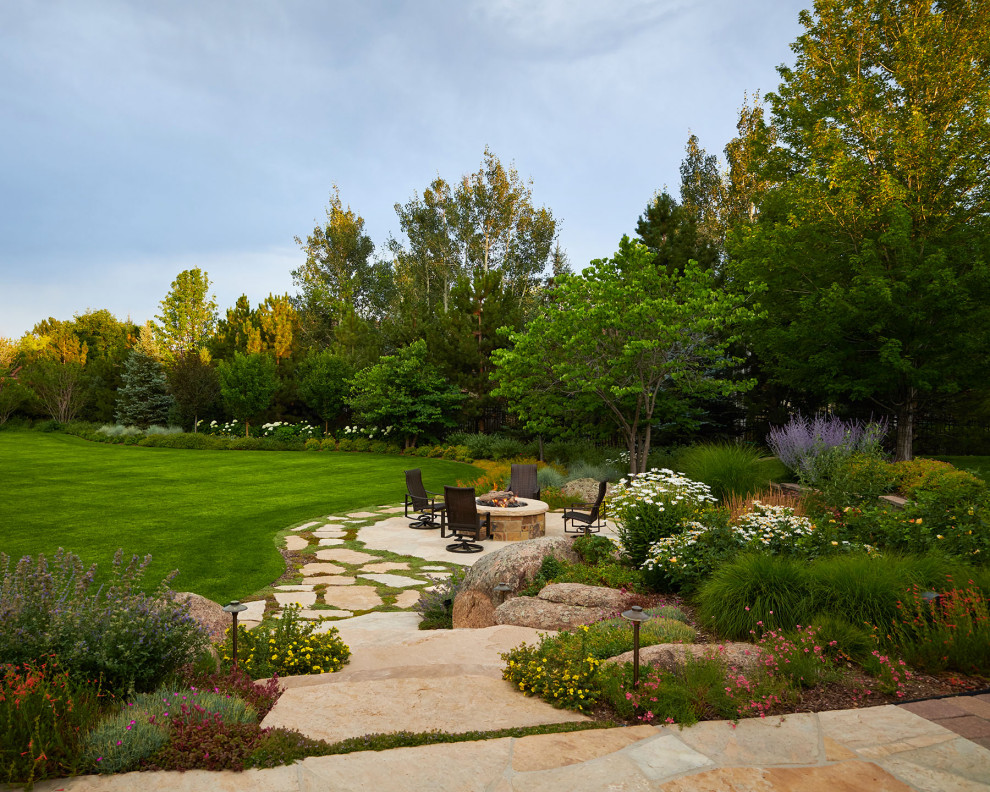 This is an example of an expansive contemporary backyard partial sun formal garden for summer in Denver with a garden path and natural stone pavers.