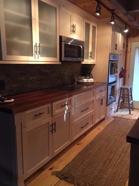 Mid-sized mountain style galley light wood floor kitchen photo with an undermount sink, shaker cabinets, light wood cabinets, wood countertops, multicolored backsplash, stone tile backsplash and stainless steel appliances