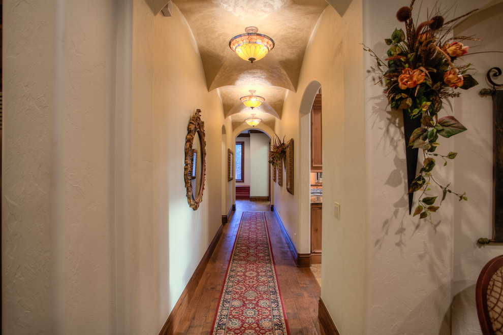 Photo of a mediterranean hallway in Oklahoma City with white walls and dark hardwood floors.