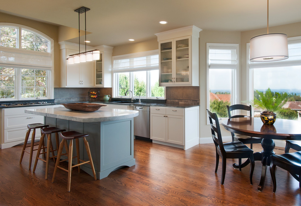 Large transitional u-shaped medium tone wood floor eat-in kitchen photo in Seattle with an undermount sink, recessed-panel cabinets, blue cabinets, granite countertops, gray backsplash, mosaic tile backsplash, stainless steel appliances and an island