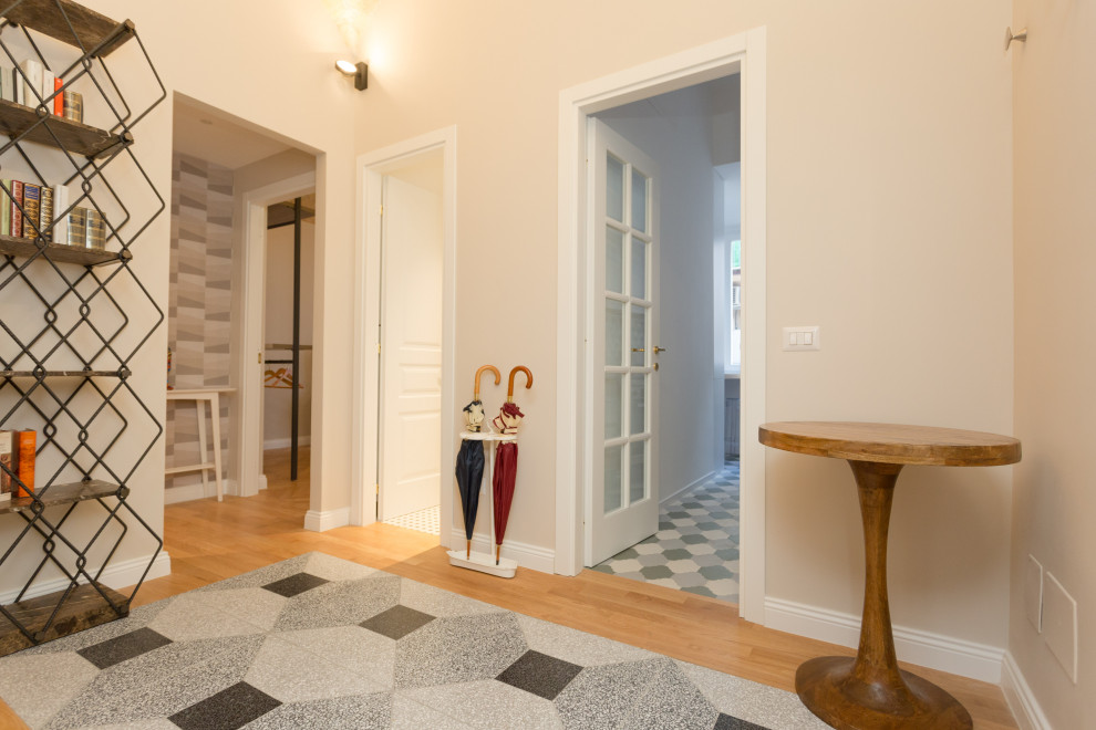 This is an example of a small contemporary foyer in Rome with light hardwood flooring and a vaulted ceiling.