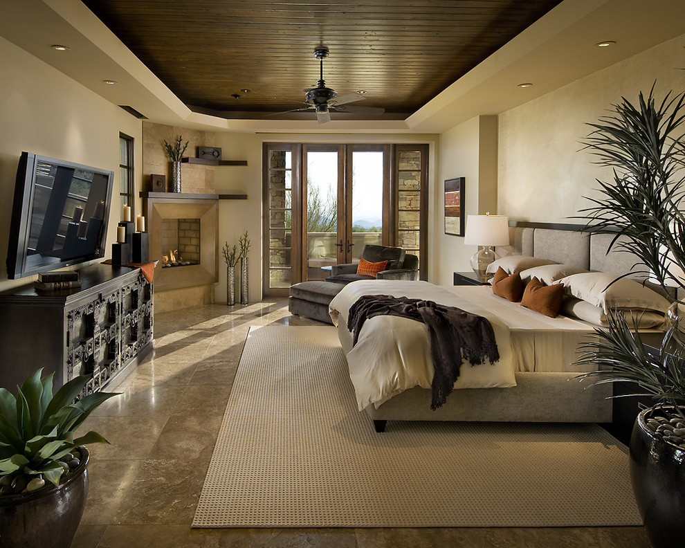 Design ideas for a contemporary bedroom in Phoenix with beige walls and a corner fireplace.