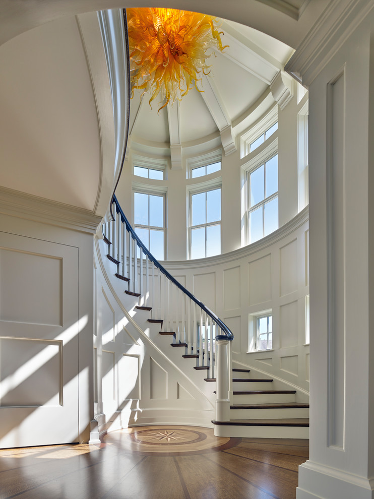 Inspiration for a mid-sized traditional wood curved staircase in Other with painted wood risers and wood railing.