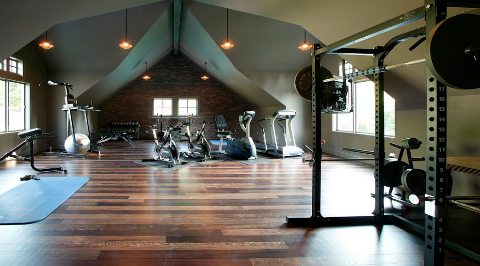 Photo of a large arts and crafts home weight room in Seattle with beige walls, dark hardwood floors and brown floor.