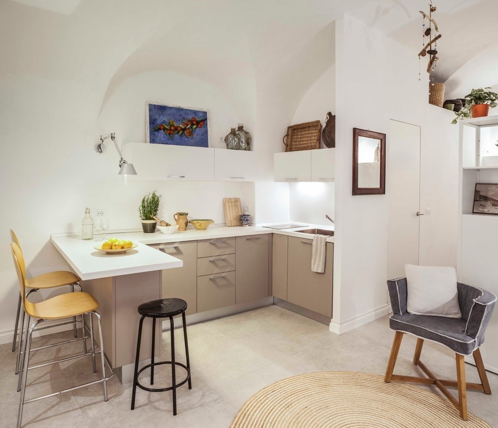 Beach style l-shaped open plan kitchen in Other with a drop-in sink, flat-panel cabinets, beige cabinets, porcelain floors, beige floor and white benchtop.