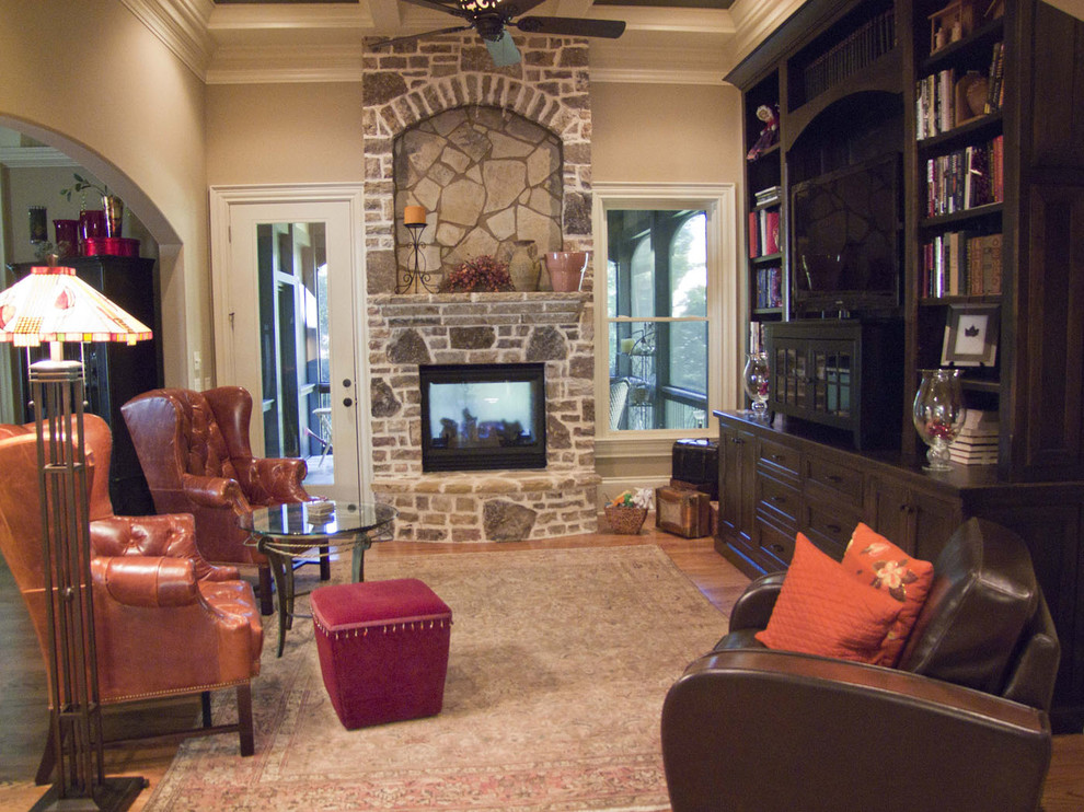 Design ideas for a mid-sized country formal enclosed living room in Atlanta with beige walls, medium hardwood floors, a two-sided fireplace, a stone fireplace surround and no tv.