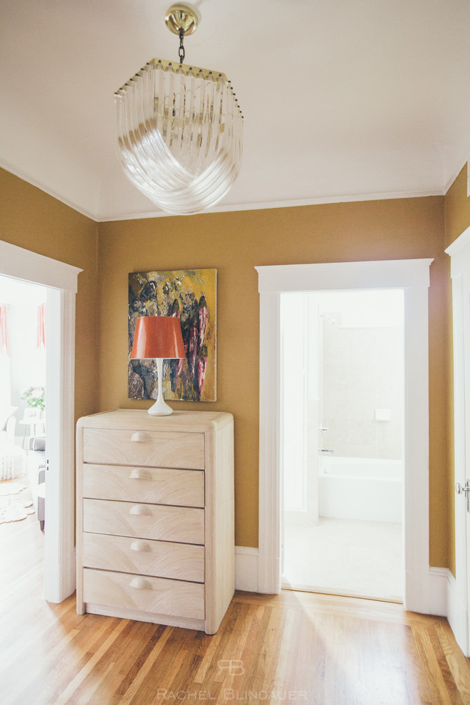 Design ideas for a small transitional hallway in Miami with yellow walls and medium hardwood floors.