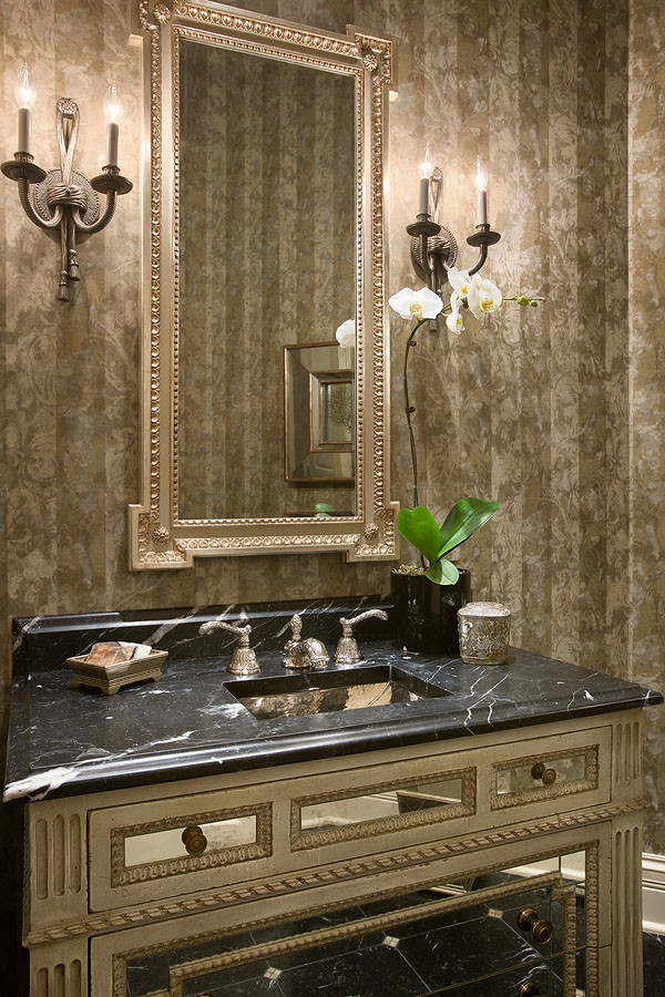 Design ideas for a mid-sized traditional powder room in Chicago with glass-front cabinets, distressed cabinets, beige walls, marble floors, an undermount sink, marble benchtops and black floor.