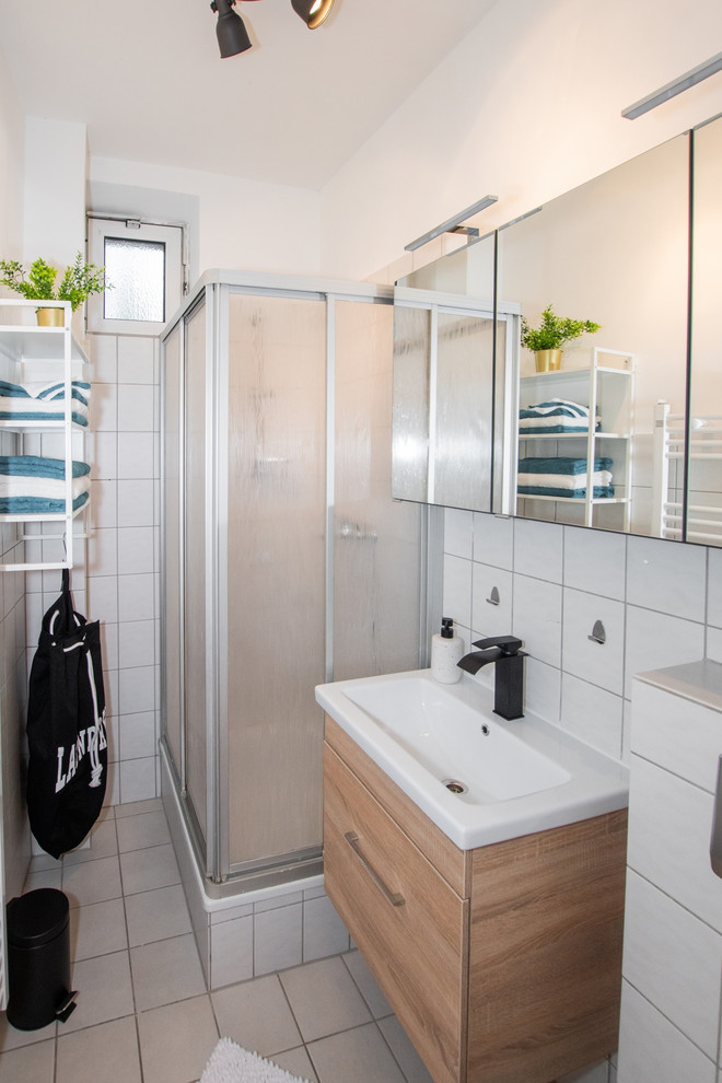 This is an example of a small contemporary 3/4 bathroom in Cologne with black walls, brown floor, flat-panel cabinets, dark wood cabinets, a corner shower, a wall-mount toilet, white tile, ceramic tile, ceramic floors, a vessel sink, solid surface benchtops, a sliding shower screen and white benchtops.