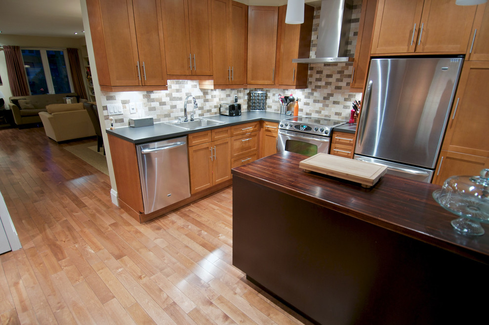 Inspiration for a mid-sized transitional u-shaped medium tone wood floor and multicolored floor enclosed kitchen remodel in Toronto with a double-bowl sink, shaker cabinets, medium tone wood cabinets, wood countertops, multicolored backsplash, porcelain backsplash, stainless steel appliances and an island