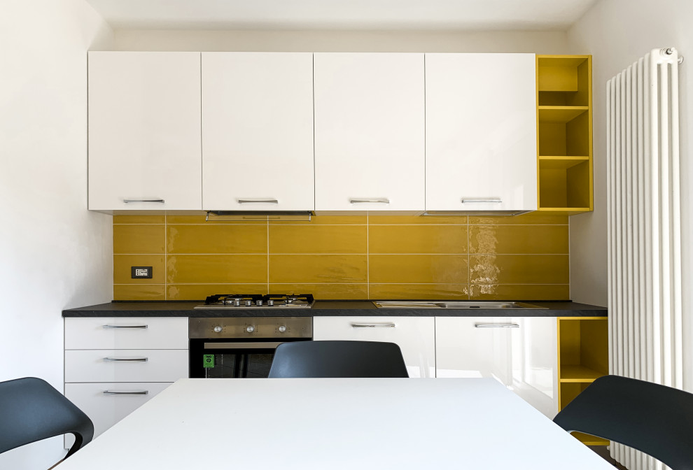 Design ideas for a small contemporary single-wall eat-in kitchen in Other with a drop-in sink, flat-panel cabinets, white cabinets, yellow splashback, stainless steel appliances, no island and black benchtop.