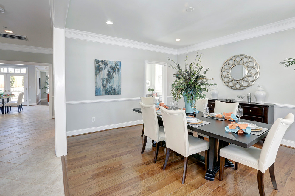This is an example of a large transitional separate dining room in DC Metro with grey walls and medium hardwood floors.