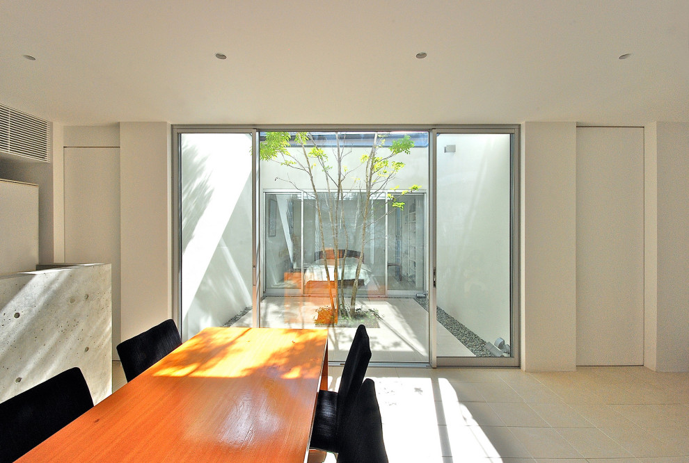 Idée de décoration pour une salle à manger ouverte sur le salon minimaliste de taille moyenne avec un sol en carrelage de céramique et un sol blanc.