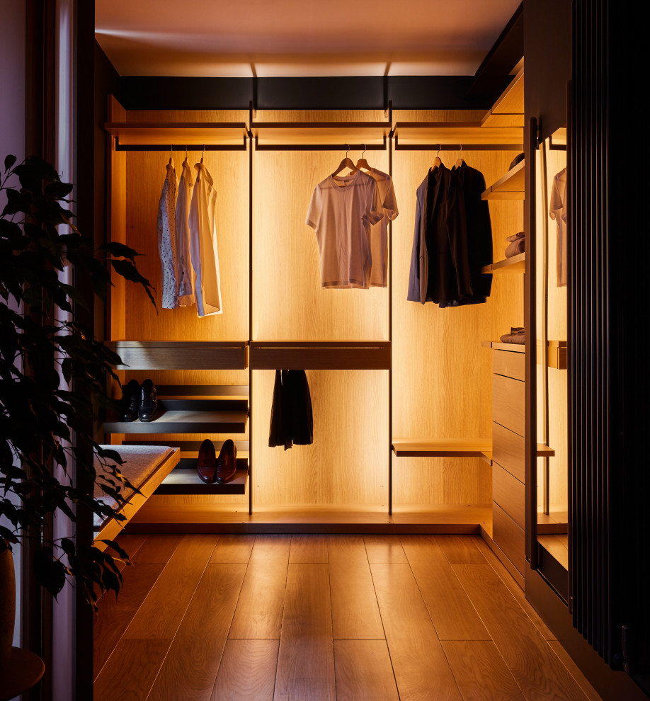 Ejemplo de armario y vestidor de hombre moderno pequeño con suelo de madera en tonos medios y puertas de armario de madera clara