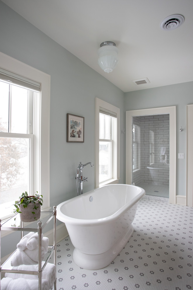 Стильный дизайн: большой главный совмещенный санузел в классическом стиле с коричневыми фасадами, отдельно стоящей ванной, душем в нише, раздельным унитазом, белой плиткой, плиткой кабанчик, синими стенами, полом из мозаичной плитки, накладной раковиной, столешницей из гранита, разноцветным полом, душем с распашными дверями, белой столешницей, тумбой под две раковины и напольной тумбой - последний тренд