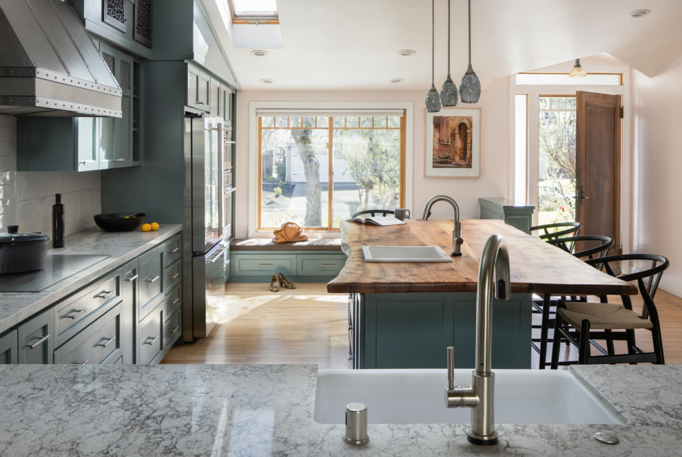 Large classic kitchen in San Francisco with a single-bowl sink, shaker cabinets, green cabinets, wood worktops, white splashback, metro tiled splashback, stainless steel appliances, medium hardwood flooring and an island.