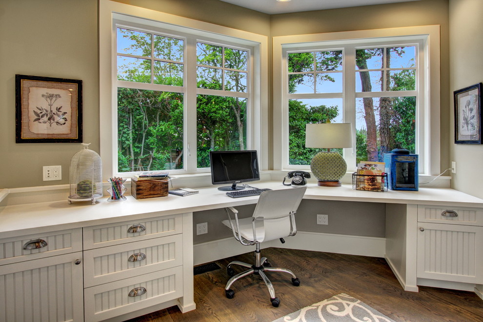 Photo of a traditional home office in Seattle with dark hardwood floors, a built-in desk and beige walls.