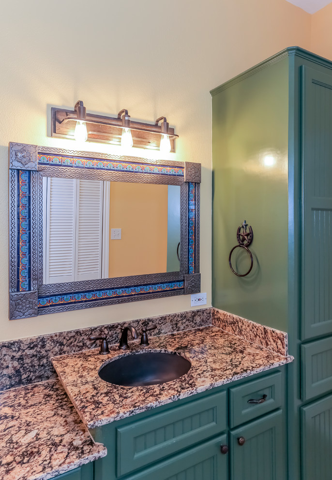 Photo of a large master bathroom in Houston with beaded inset cabinets, green cabinets, a double shower, a two-piece toilet, brown tile, porcelain tile, orange walls, porcelain floors, an undermount sink and granite benchtops.