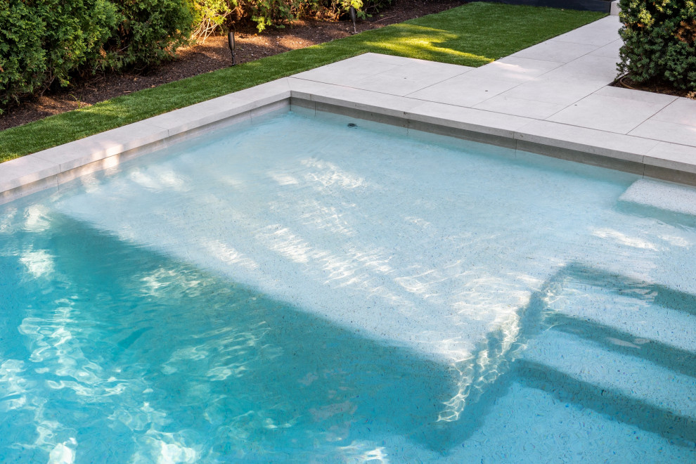 Imagen de piscina tradicional renovada pequeña rectangular en patio lateral con paisajismo de piscina y adoquines de piedra natural