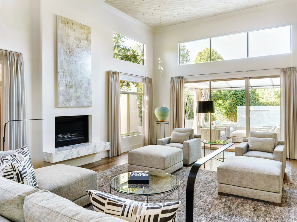 Photo of a mid-sized contemporary open concept living room in Phoenix with white walls, dark hardwood floors, a standard fireplace, a plaster fireplace surround and no tv.
