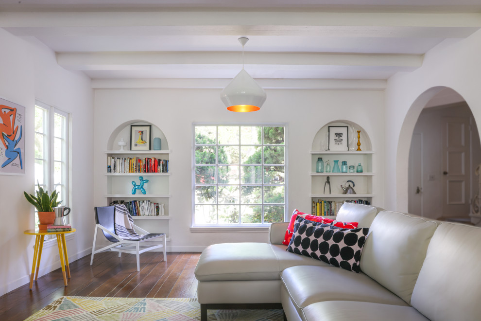 Foto di un soggiorno minimal di medie dimensioni e chiuso con pareti bianche, parquet scuro, travi a vista, libreria e pavimento marrone