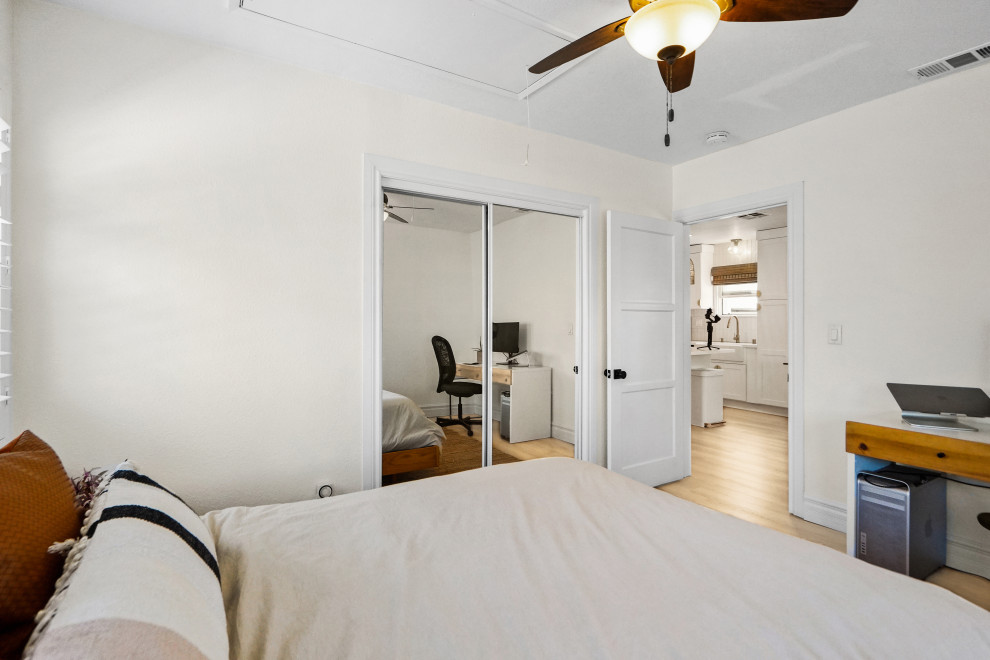Diseño de habitación de invitados abovedada de estilo de casa de campo de tamaño medio con paredes blancas, suelo vinílico y suelo beige