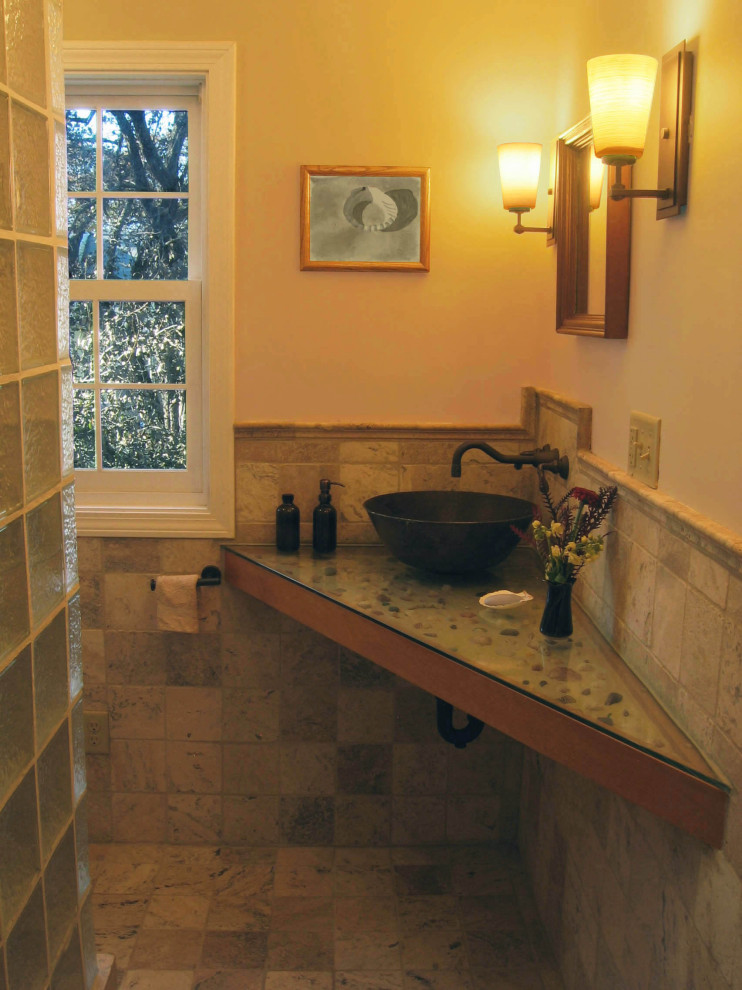 Inredning av ett modernt litet badrum med dusch, med en dusch i en alkov, en toalettstol med separat cisternkåpa, travertinkakel, gula väggar, travertin golv, ett fristående handfat, bänkskiva i glas, med dusch som är öppen och brunt golv