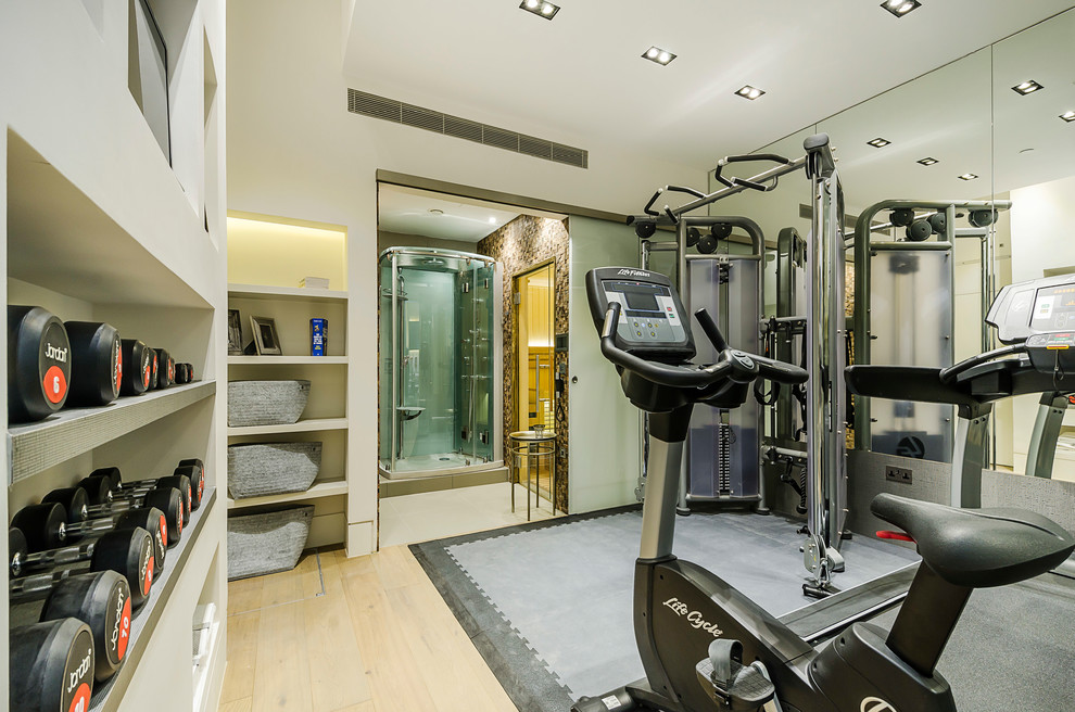 Design ideas for a small contemporary multipurpose gym in London with grey walls, light hardwood floors and grey floor.