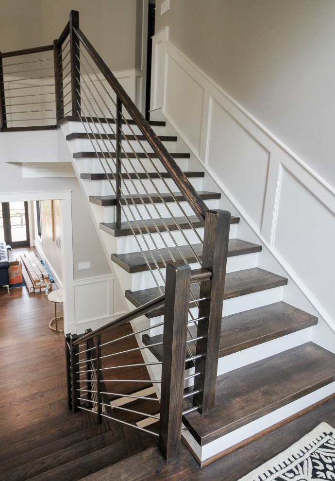 Large contemporary wood u-shaped staircase in DC Metro with wood risers and mixed railing.