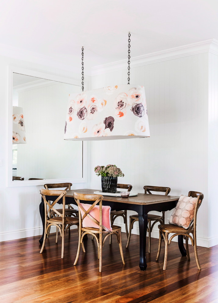 Inspiration for a beach style dining room in Melbourne with white walls and medium hardwood floors.