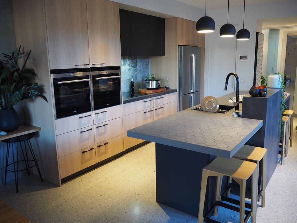 Design ideas for a mid-sized contemporary galley eat-in kitchen in Canberra - Queanbeyan with a double-bowl sink, light wood cabinets, tile benchtops, blue splashback, glass sheet splashback, black appliances, concrete floors and with island.