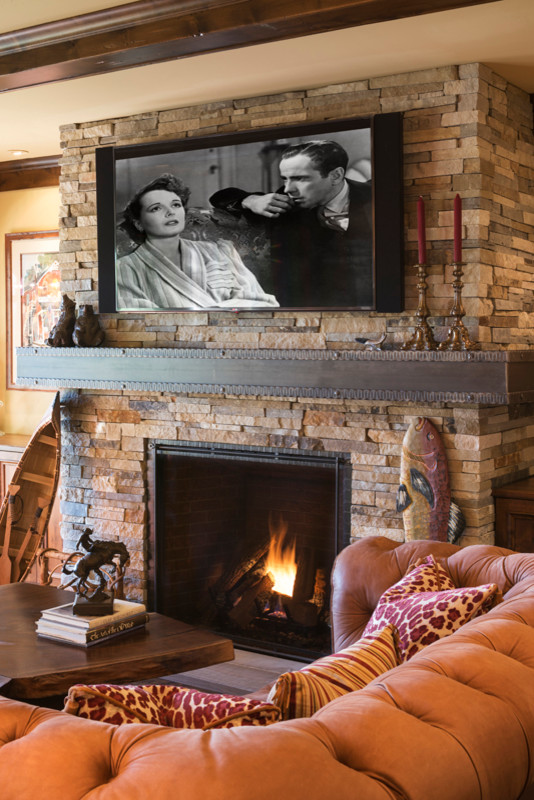 Photo of a large country walk-out basement in Minneapolis with beige walls, a standard fireplace and a stone fireplace surround.