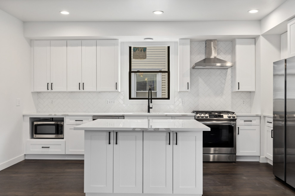 Example of a large transitional u-shaped dark wood floor and brown floor eat-in kitchen design in Minneapolis with a single-bowl sink, shaker cabinets, white cabinets, quartz countertops, white backsplash, ceramic backsplash, stainless steel appliances, an island and white countertops